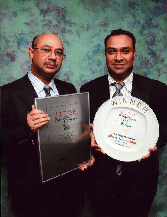 Two men holding awards. The Grand Eastern Indian Restaurant, Bath